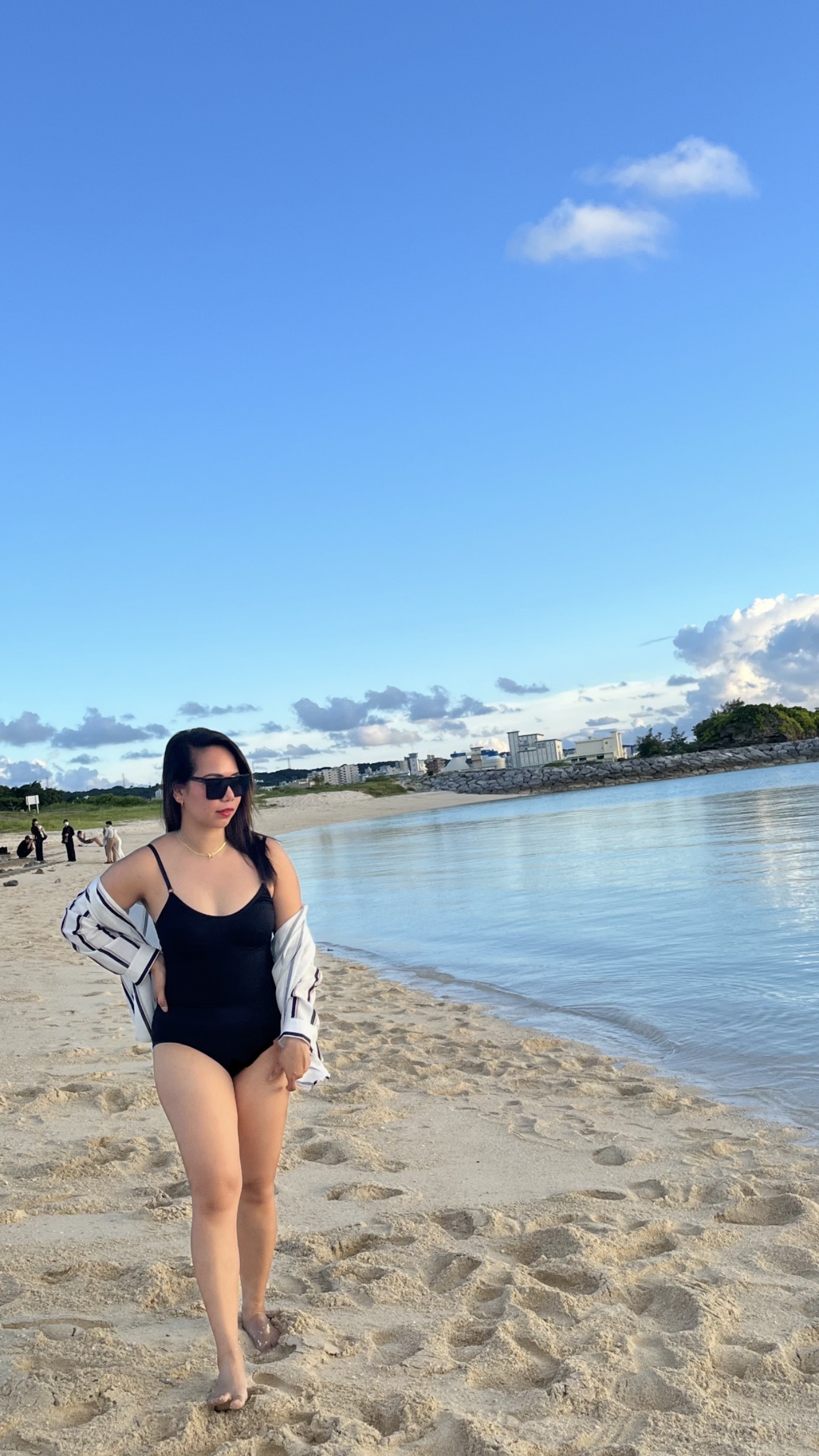 Maribel wearing a black swimsuit at the beach